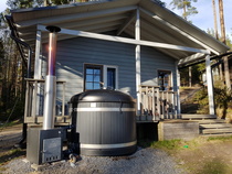 Rantasaunalla kylpytynnyri sekä saunakamarissa levitettävä sohva ja pieni jääkaappi